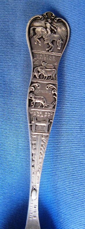 Elkton - Mary McKinney Mines Cripple Creek Colorado Reverse Handle.JPG - SOUVENIR MINING SPOON ELKTON & MARY MCKINNEY MINES CRIPPLE CREEK COLORADO - Sterling silver souvenir mining spoon, embossed donkey loaded up with mining equipment in bowl, donkey carries sign that says “I helped built P.P.RR” (Pikes Peak Railroad), handle depicts scenes of the Elkton and Mary McKinney Mines in Cripple Creek, Colorado, also features a gold pan and pick and shovel, reverse features a windlass and mine bucket marked mine and shaft, reverse marked Sterling with rare maker mark E.L.D. for Eugene L. Deacon Jewelry Co. of Denver, CO maker of Sterling spoons from 1900 to 1912, 5 1/8 in. long [Elkton Mine - Located in Cripple Creek, Colorado, Elkton came to life in 1891 after a blacksmith from Colorado Springs named William Shemwell staked a claim in the Cripple Creek area. The town sprung up around the mine to support the miners and their families. By 1892, the mine still had not produced results and Shemwell decided to sell the claim to three brothers: George, Douglas and Sam Bernard.  By 1894, the Bernard brothers had also been unsuccessful and gave the mine only two weeks before they would consolidate their loses. Near the end of these two weeks, a vein of gold was discovered which produced $40,000 within a week. The mine had finally become a success.  In 1899, a man by the name of Ed De LaVergne proposed to merge his mine located directly next to the Elkton with the Elkton. With this move, the Elkton mine became one of the largest mines in the Cripple Creek area. The mine would yield more than $16 million in gold and would be active until 1956. Several of the men involved, including Ed De LaVergne and the Bernards, became millionaires, but most of them were dead broke again by the time of their deaths.  The town itself was never actually platted, but the area simply became known as Elkton, Colorado. It had its own post office for a while and grew to reach a population of 2900 people at its peak.  Mary McKinney Mine - The Mary McKinney Mine was founded in May of 1891. An unusual feature of the mine was the large cribbing wall that was built to prevent the mine’s dump rock from falling onto the railroad bed.  The Mary McKinney Mine which was located in Squaw Gulch in the Cripple Creek Gold Mining District was started by Frank Castello and the Houghton brothers.  Banker and mining baron David H. Moffat heavily bought into the property and by 1894 the owners were able to turn the property into one of the most productive in the gold mining district. Mary McKinney Mine holdings comprised 144 acres on Raven and Gold Hills within the town of Anaconda.  . Founded in 1894, the town was sprawled along a half mile of Squaw Gulch, about halfway between Cripple Creek and Victor. Anaconda was a composite of three other mining camps: Squaw Gulch, Mound City and Barry.  Once a bustling town of over 1,000 persons, the town was supported mainly by the Mary McKinney Mine. During the winter of 1904, a fire started that pretty much annihilated the town.  Unlike the massive relief efforts that rebuilt nearby Victor and Cripple Creek after their fires, Anaconda was left to die a slow death. While the mines were still in operation after the fire, most residents simply moved away.  Anaconda’s population fell from 1,000 to 250 and continued a steady decline to today’s ghost town status. The mine eventually closed in 1953. Over its 62 year history the Mary McKinney Mine yielded more than eleven million dollars in gold.]  